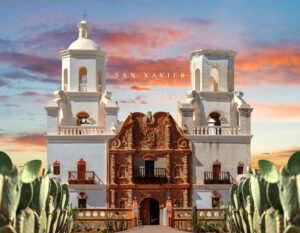 Welcome to Arizona: Mission San Xavier del Bac’s twin white towers and ornate façade at sunset, framed by prickly-pear cacti.