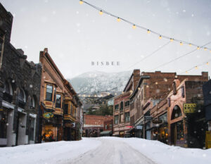 Welcome to Arizona: snowy main street in historic Bisbee with glowing string lights and mountains in the background.